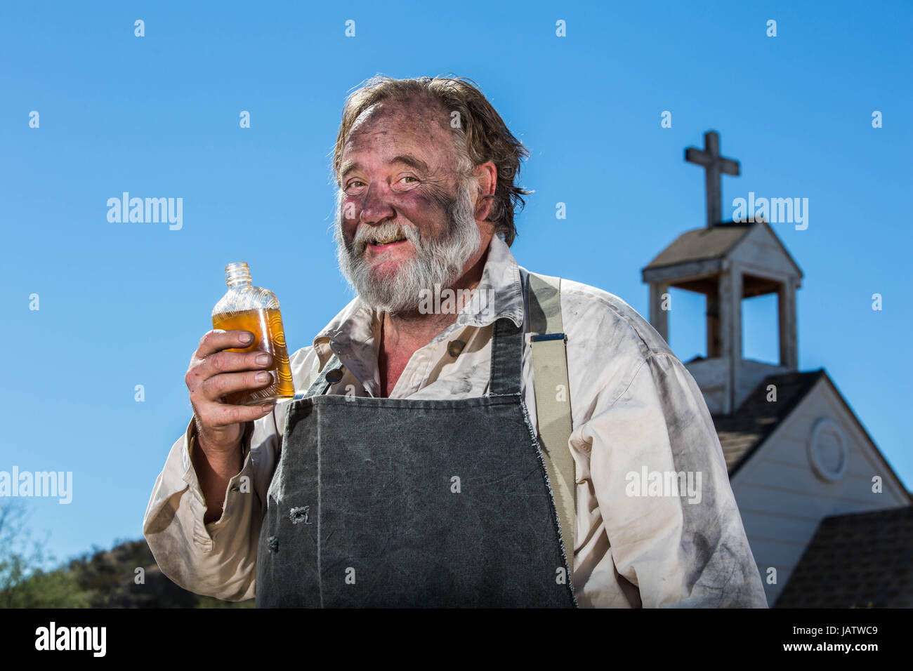 Old West Drunkard Drinks a Bottle of Alchohol Stock Photo