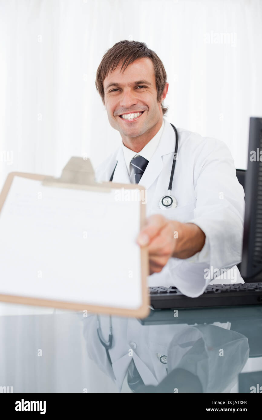 Smiling doctor showing his clipboard while looking at the camera Stock ...