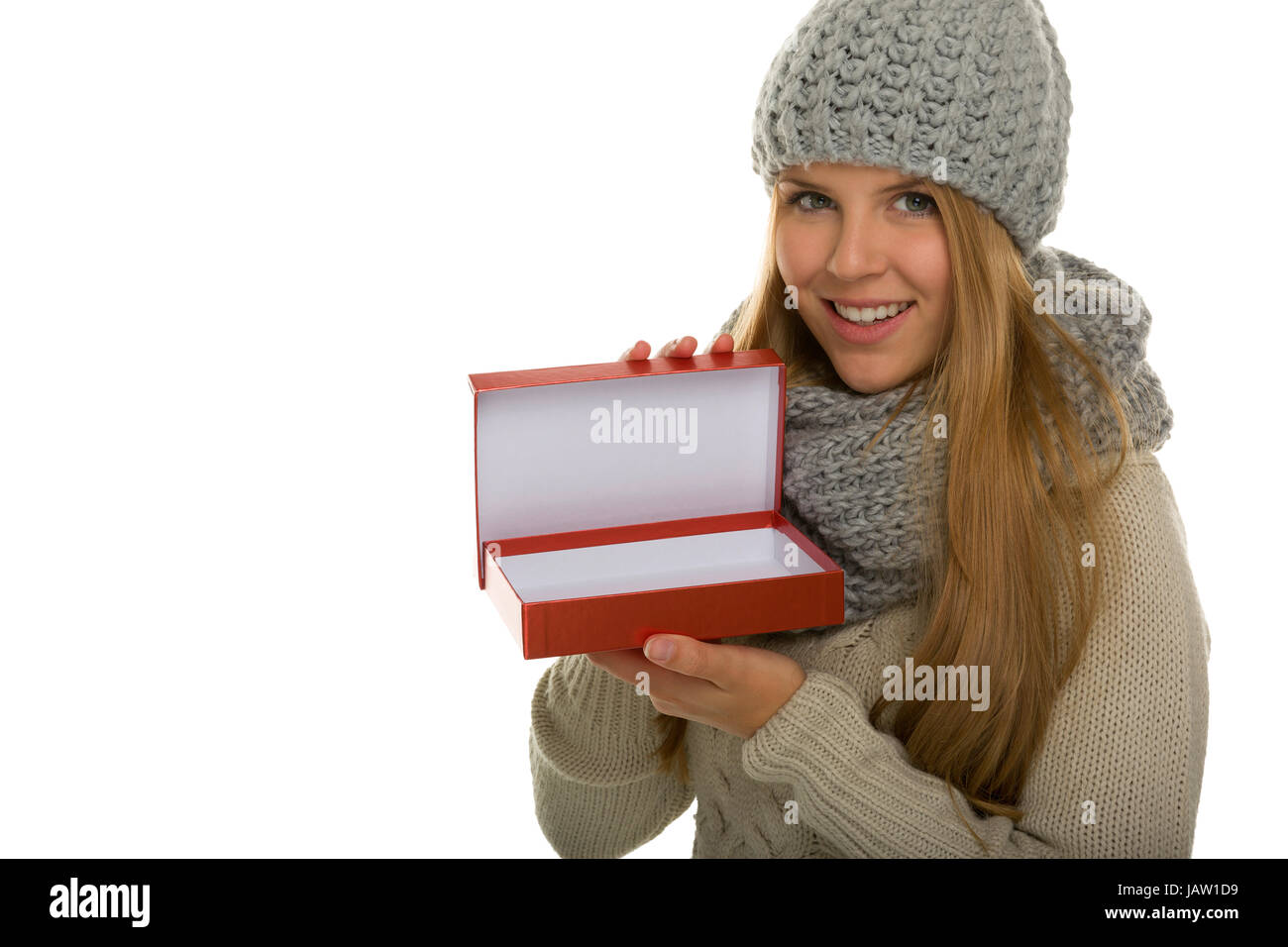 Junge Frau / Mädchen trägt Strickware und zeigt ein geöffnetes Geschenk. Inhalt kann nach Bedarf hinzugefügt werden Stock Photo