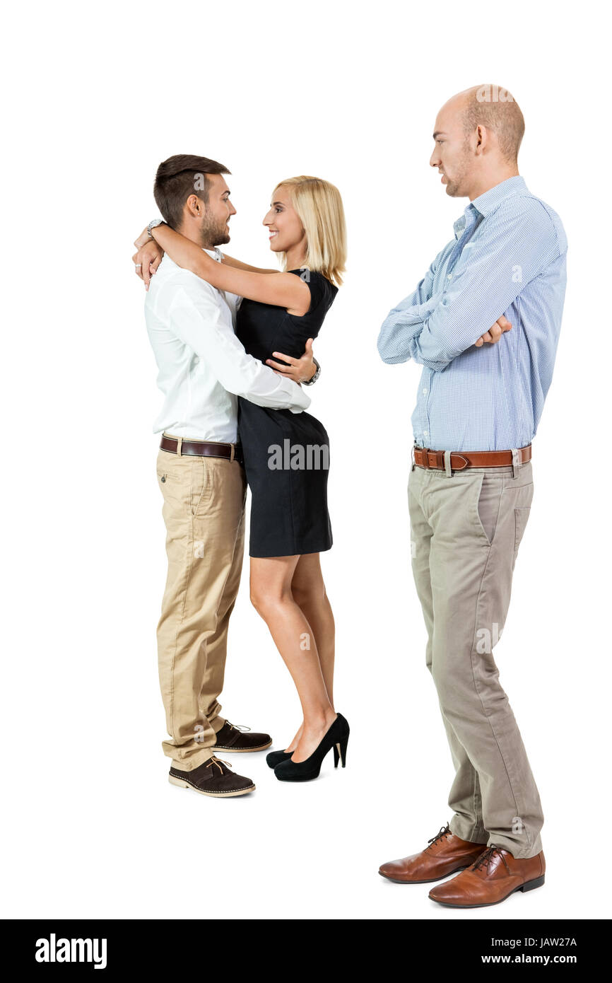 junger erwachsener mann eifersüchtig auf verliebtes paar im hintergrund isoliert portrait Stock Photo