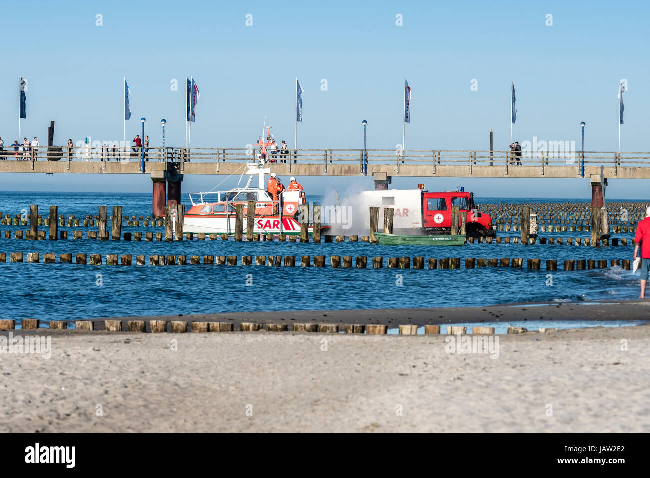 Truck move a small emergency rescue cruiser into the sea, part of a skill presentation at wharf of Zingst during festival 'Horizonte', Baltic Sea, pen Stock Photo