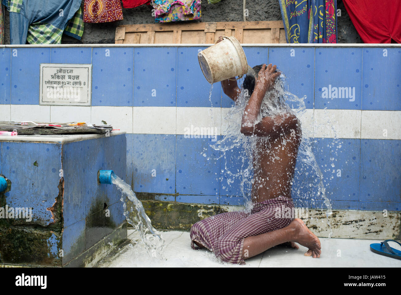 A man bathes himself at a roadside bathing place in Kolkata (Calcutta), West Bengal, India Stock Photo