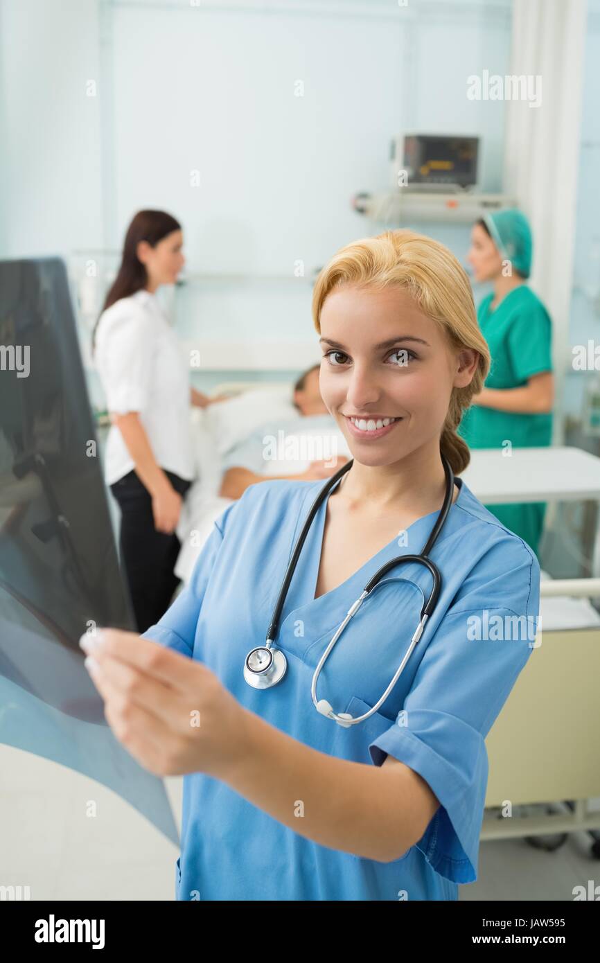 Blonde nurse holding a X-ray while smiling Stock Photo