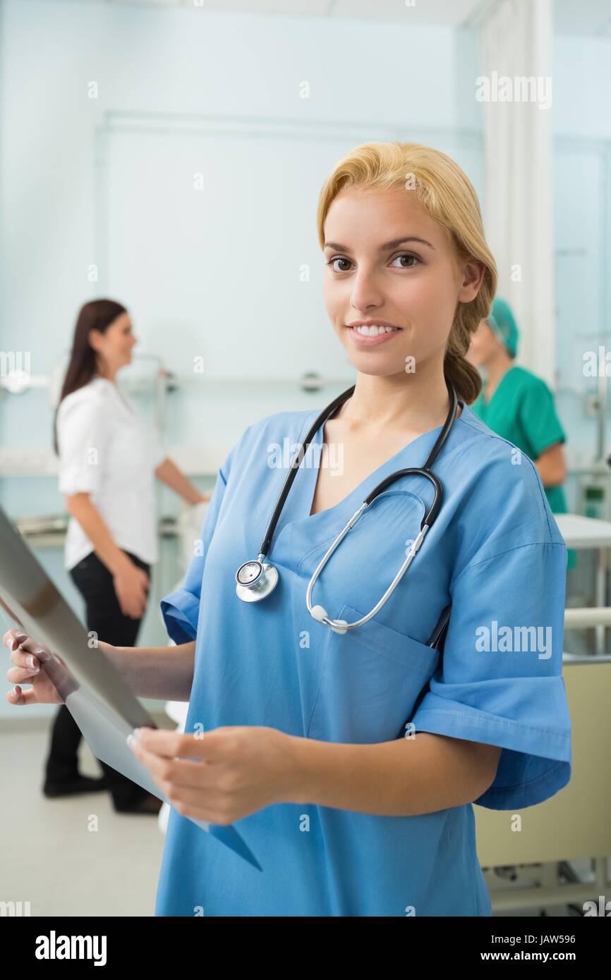 Blonde nurse holding a X-ray while looking at camera Stock Photo