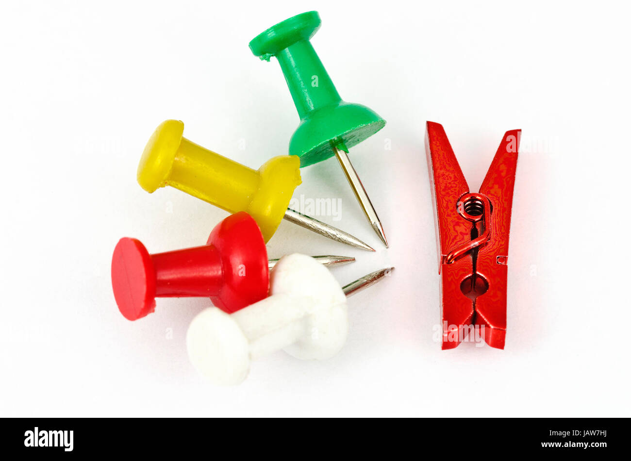 Vier Pins und eine rote Miniaturwäscheklammer aus dem Bürobedarf; four pins and a red miniature clothespin from the office equipment Stock Photo