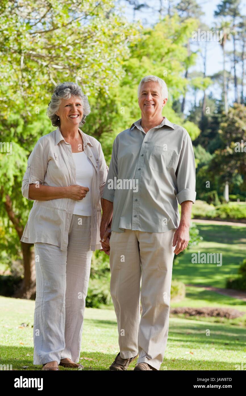 couple holding hands in park and smiling Stock Photo - Alamy
