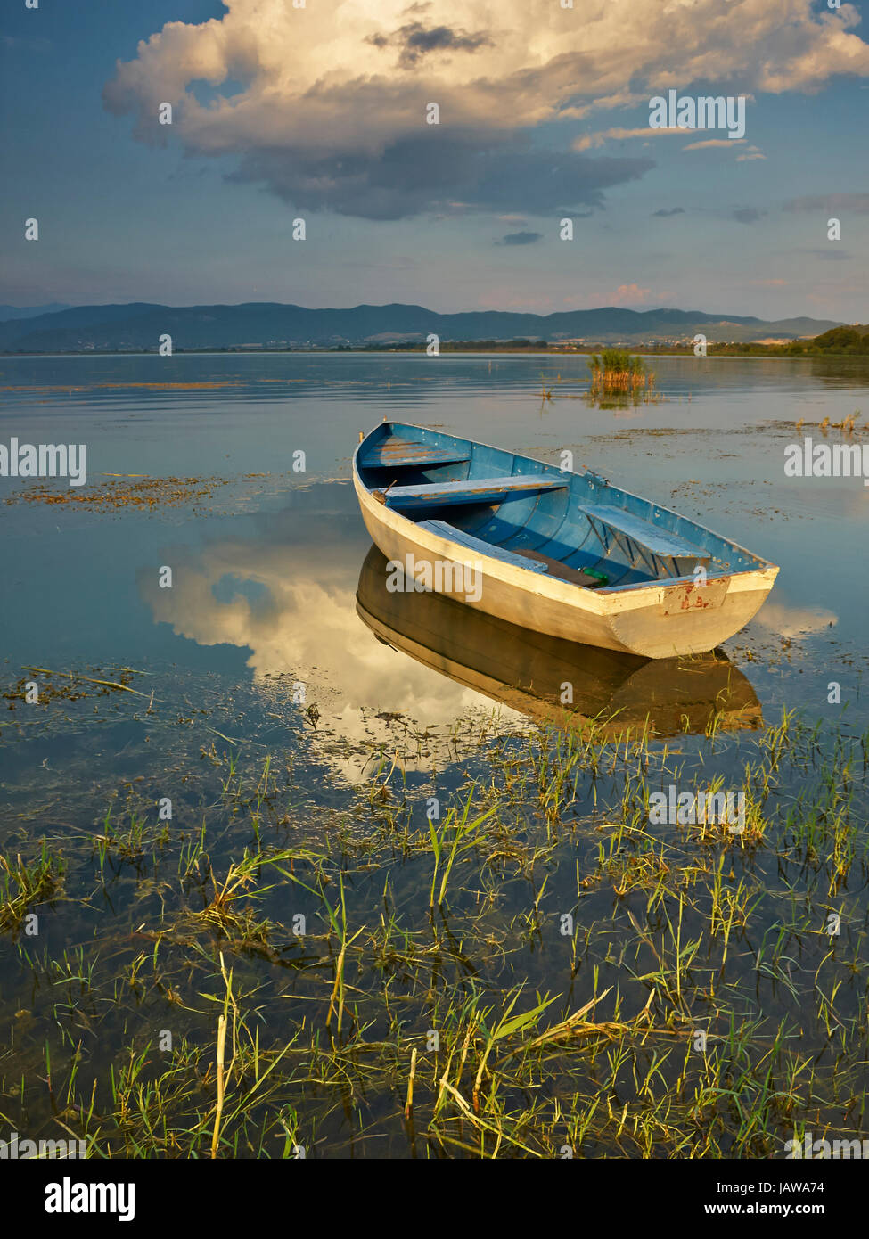 Boat on sunset in the lake Stock Photo - Alamy