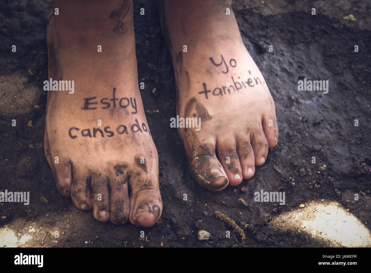 Photograph of a pair of human feet and the phrase in spanish Estoy cansado, yo tambien, which
