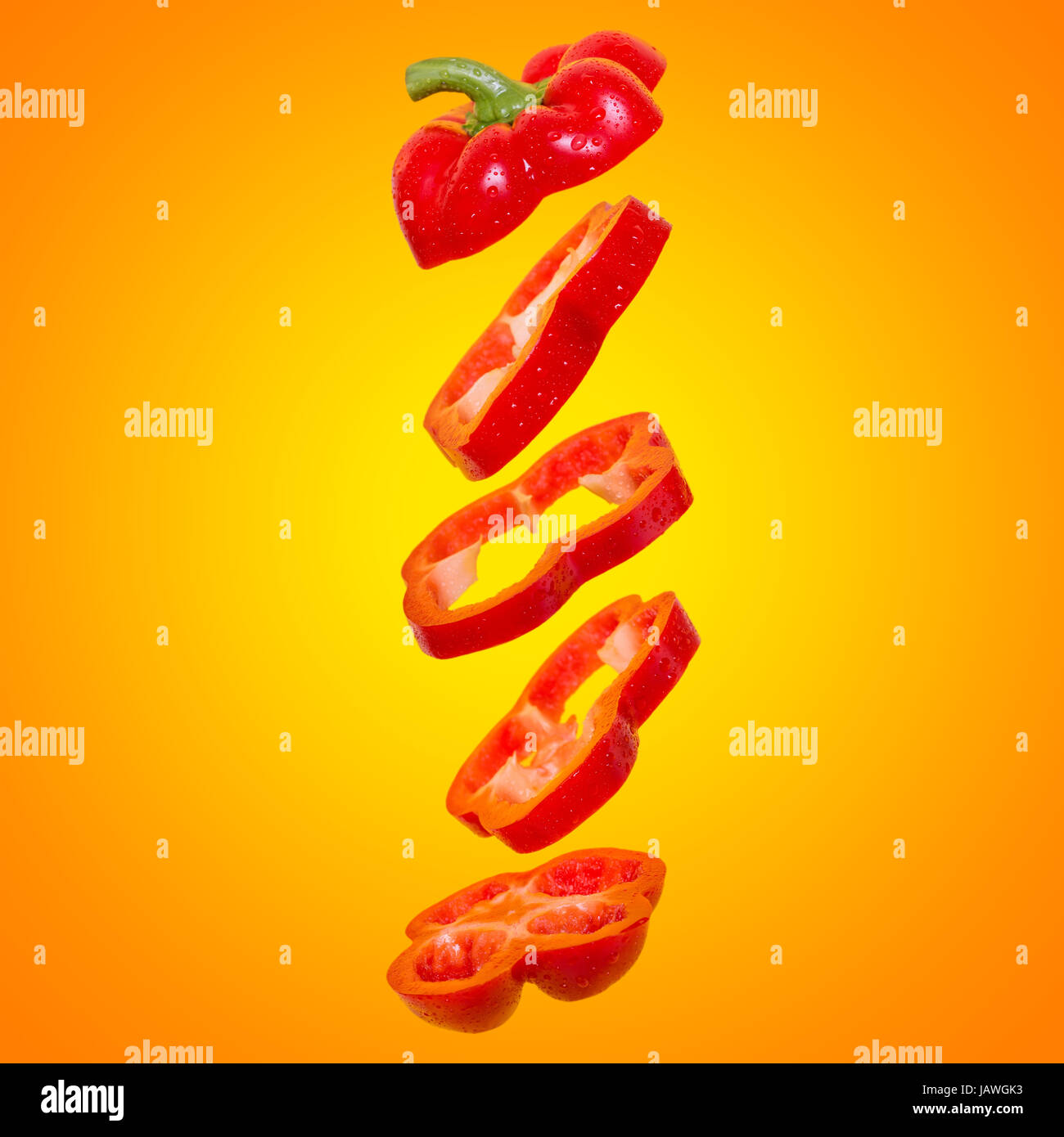 Creative concept with flying orange paprika. Sliced floating bell pepper on an orange background Stock Photo