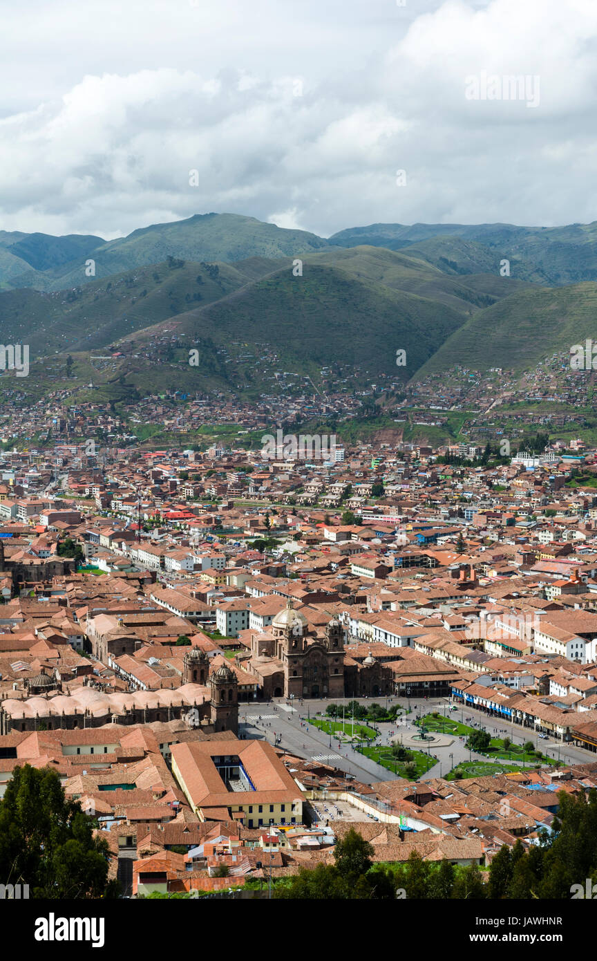 The city and suburbs of Cusco fill an Andes valley with terracotta roof tiles. Stock Photo