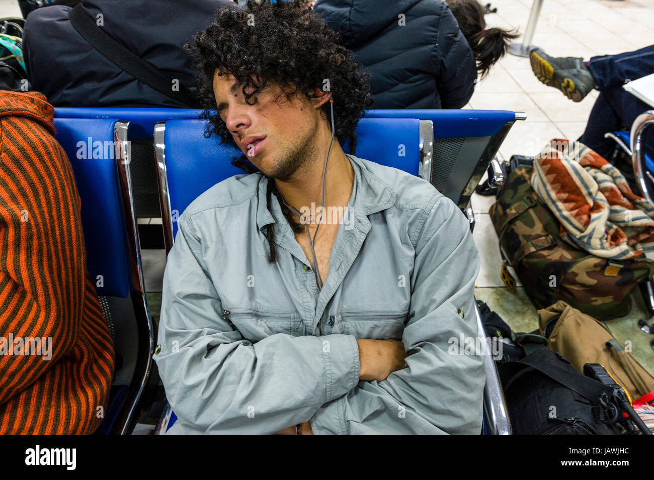 People sleeping and waiting to board planes in an airport. Stock Photo