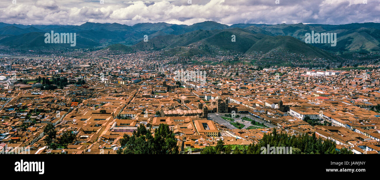 The city and suburbs of Cusco fill an Andes valley with terracotta roof tiles. Stock Photo