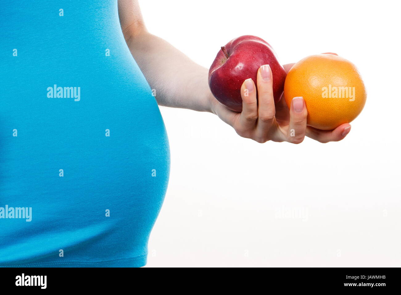 Pregnant woman holding fresh orange and apple, healthy food and