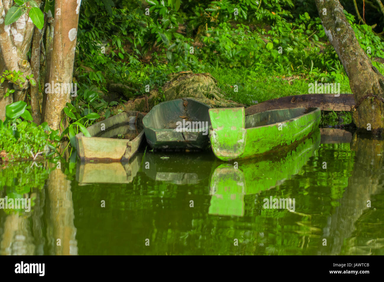 Old blue fishing wooden boat in a calm lake water Stock Photo - Alamy