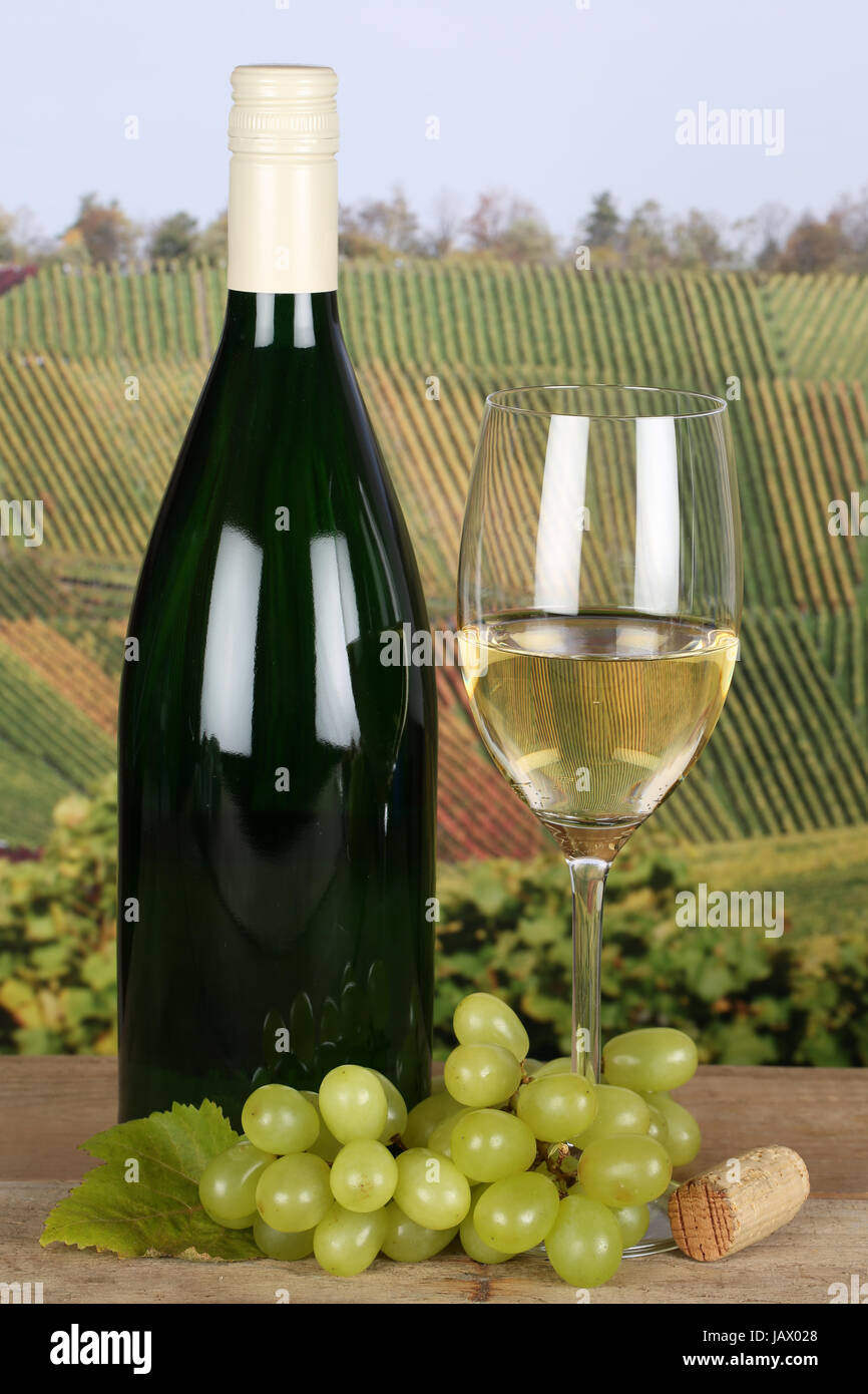Weißwein in einer Weinflasche und im Weinglas in den Weinbergen Stock Photo