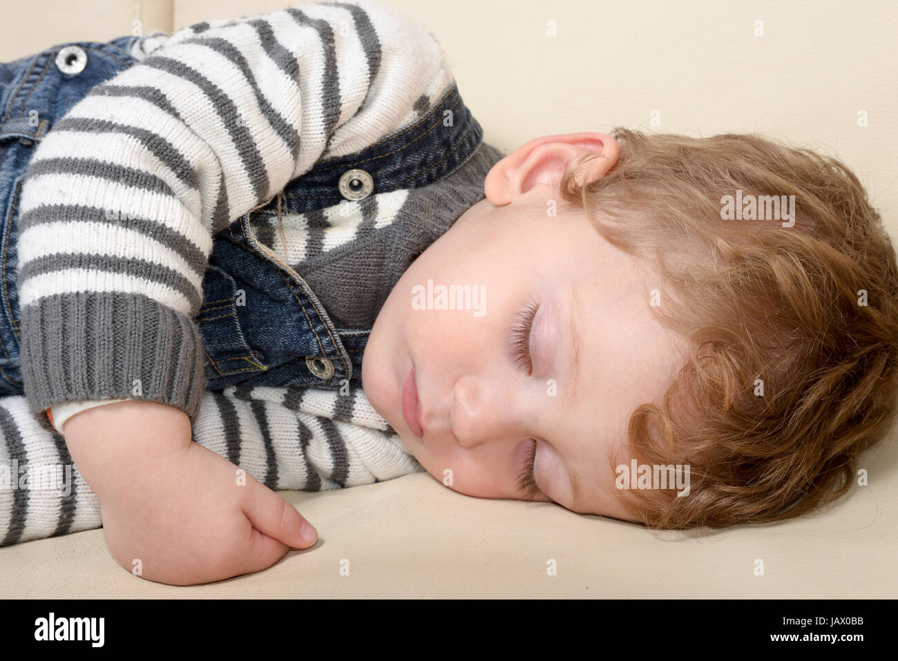 Baby sleeping peacefully on the couch at home Stock Photo
