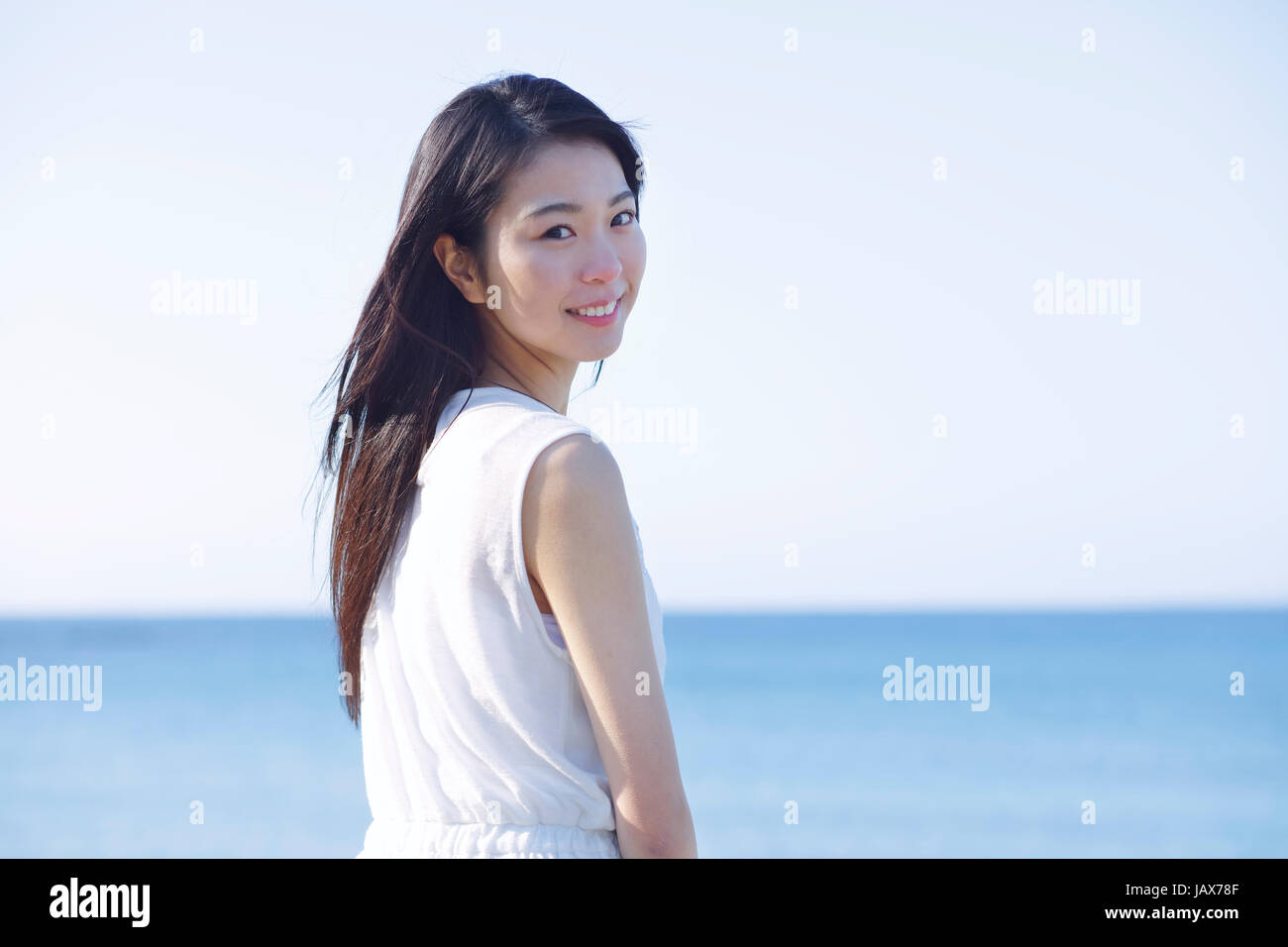 Young Japanese woman in a white dress by the sea, Chiba, Japan Stock Photo