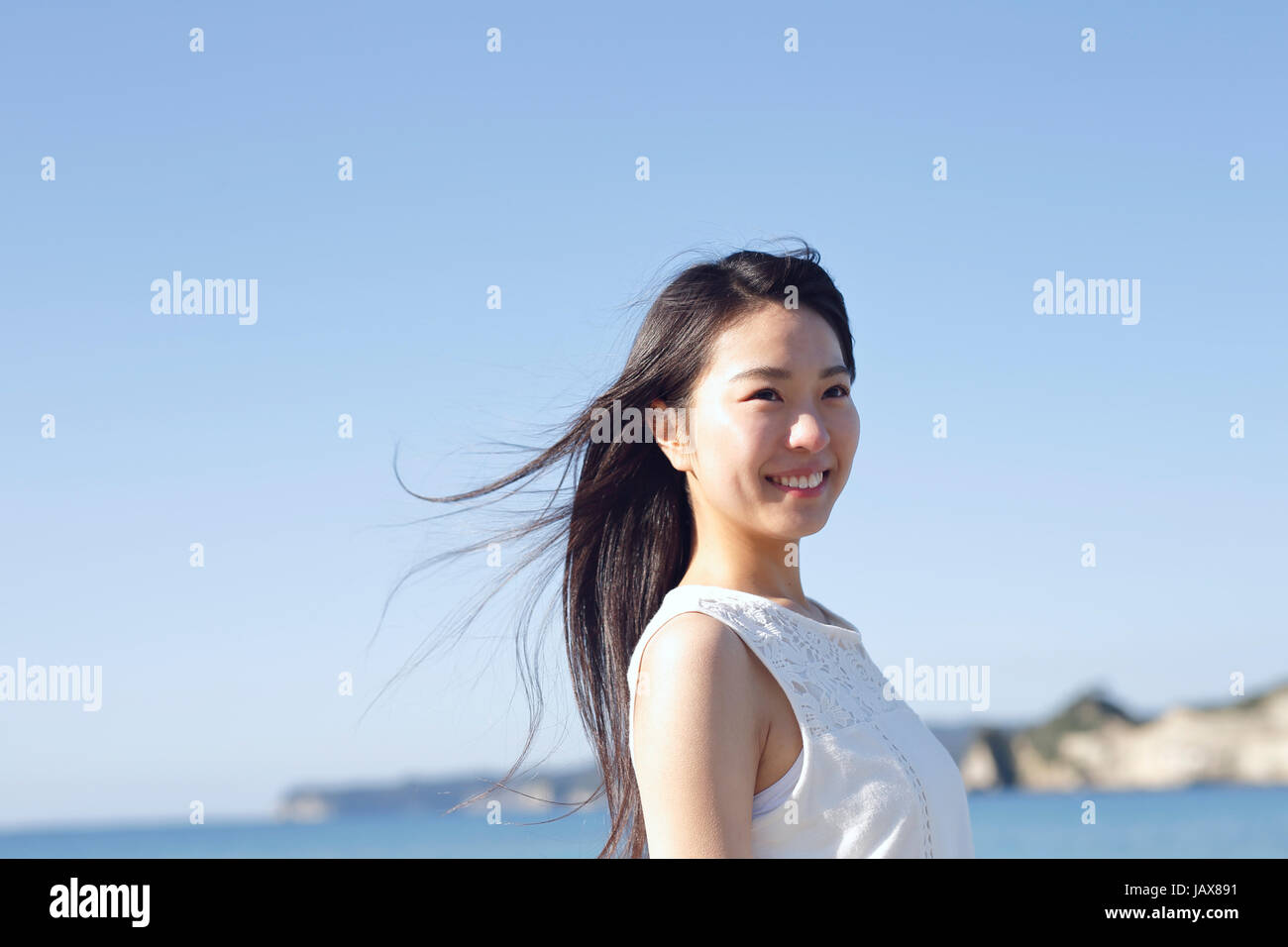 Young Japanese woman in a white dress by the sea, Chiba, Japan Stock