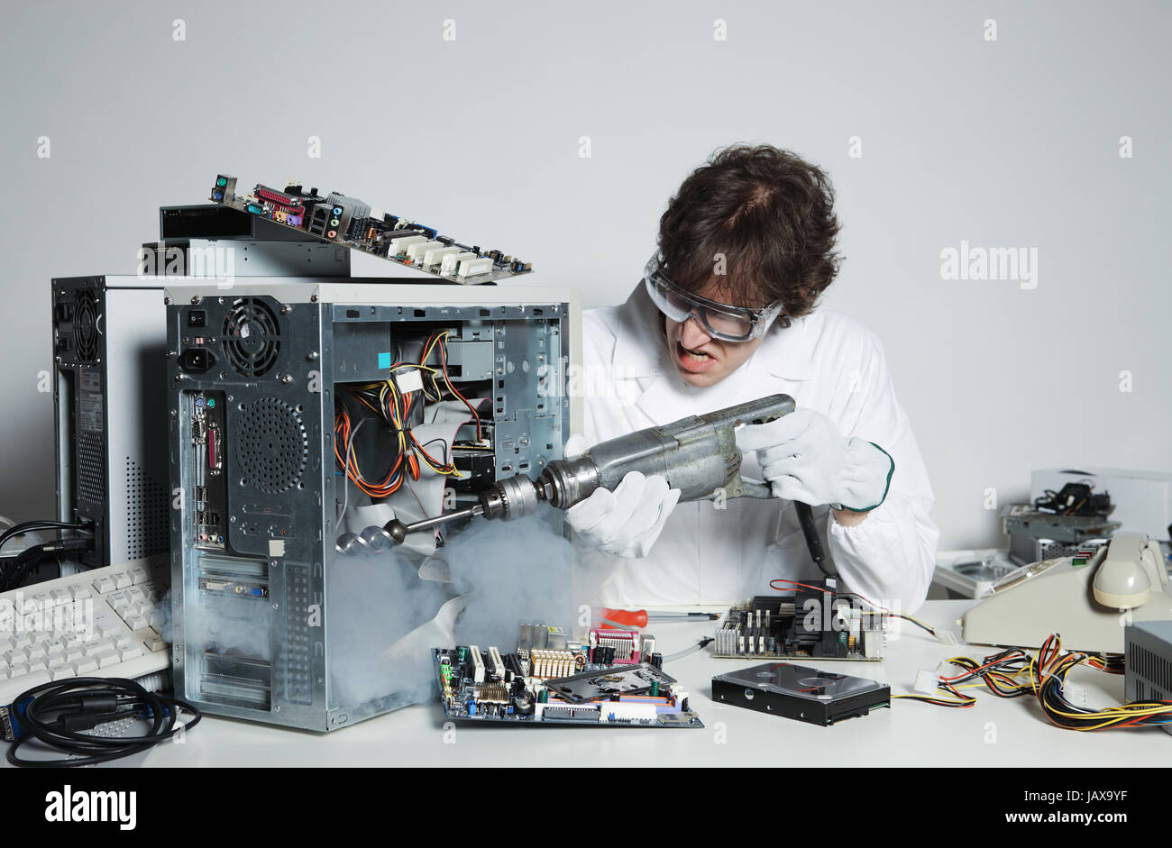 Crazy computer technician is trying to repair a computer with a drill ...