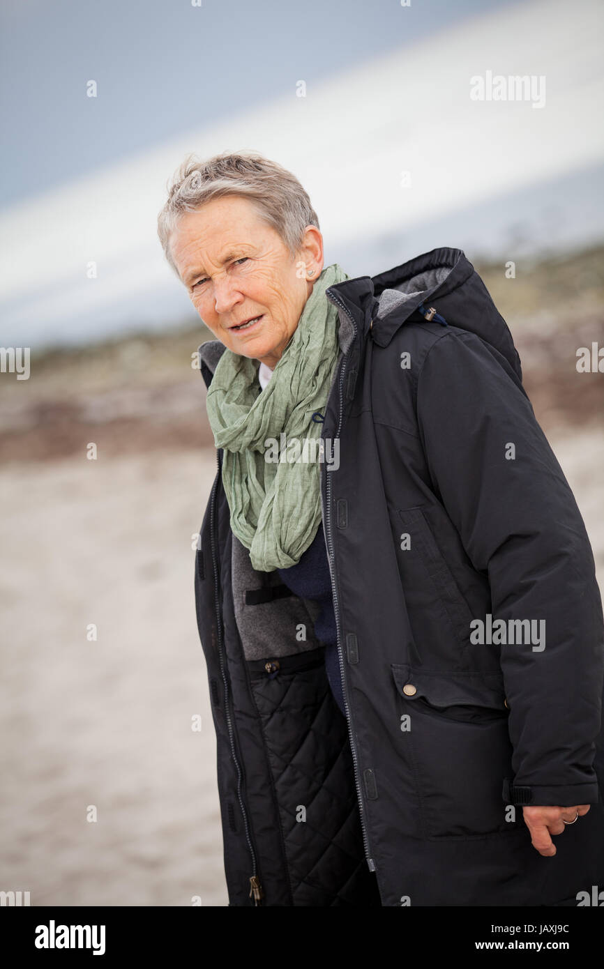 lachende glückliche ältere frau seniorin im herbst draussen mit jacke und schal Stock Photo