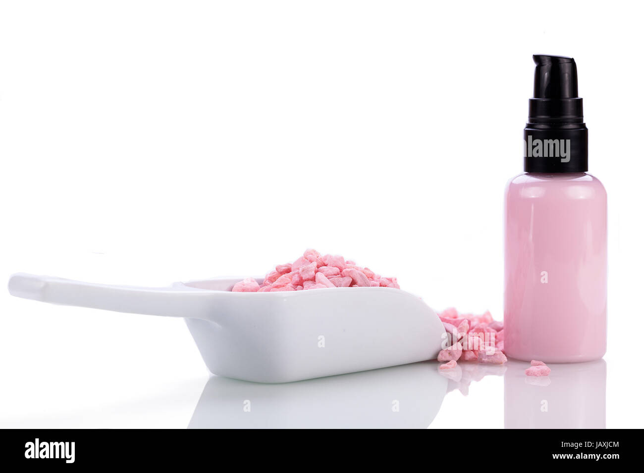 kosmetik spender mit rosa körper pflege lotion und bade aroma salz isoliert wellness spa Stock Photo