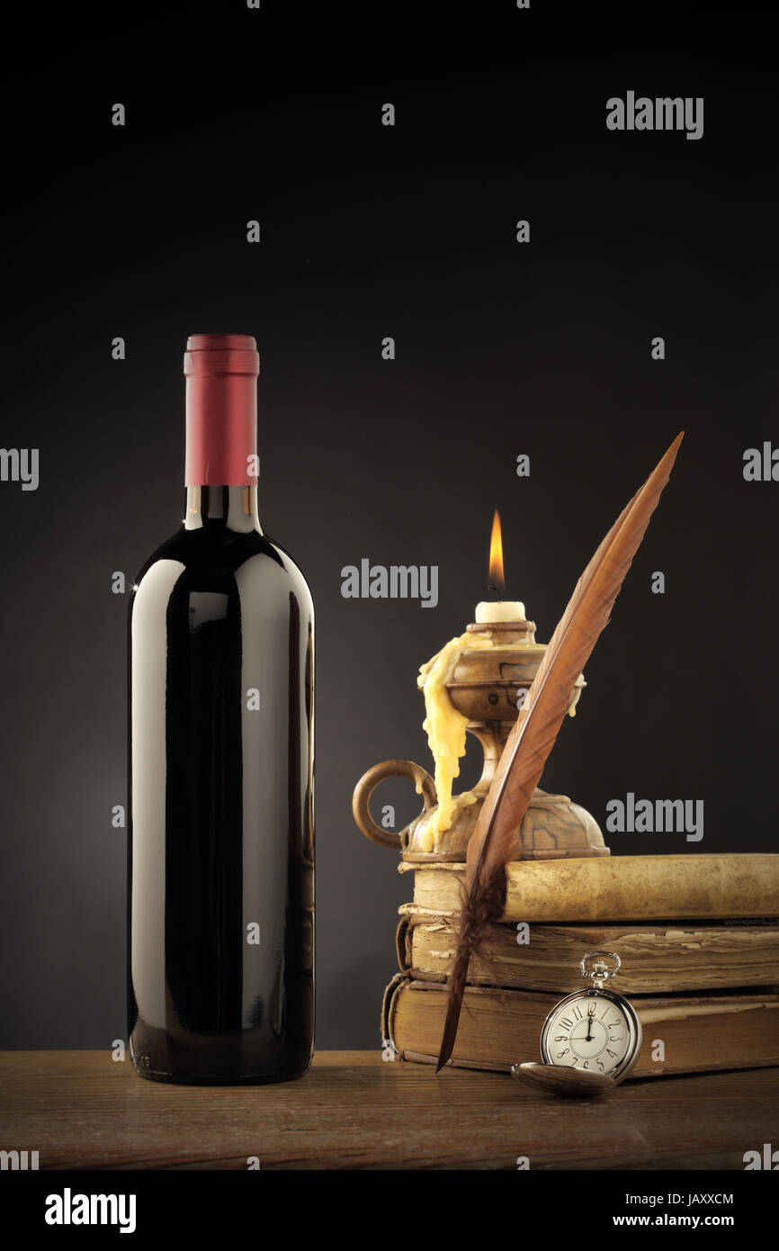 Wine bottle with old books and candle Stock Photo Alamy