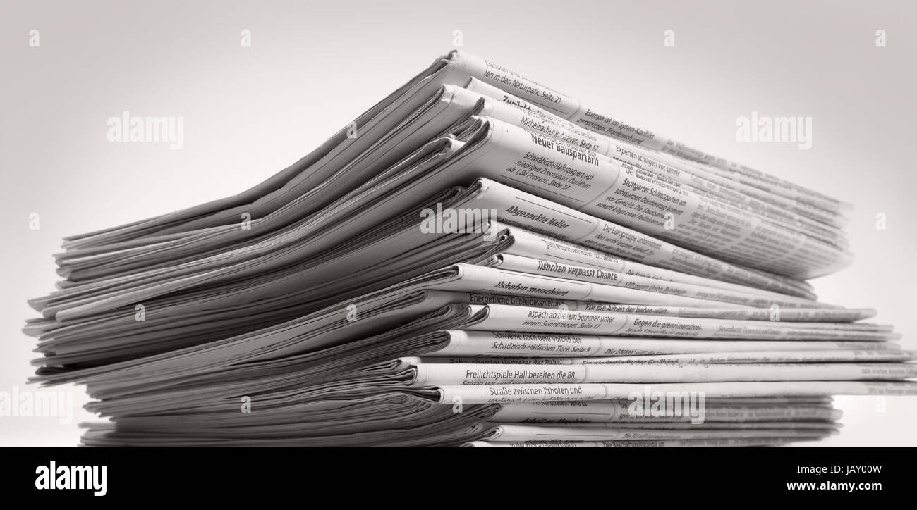 lots of stacked newspapers in light back Stock Photo