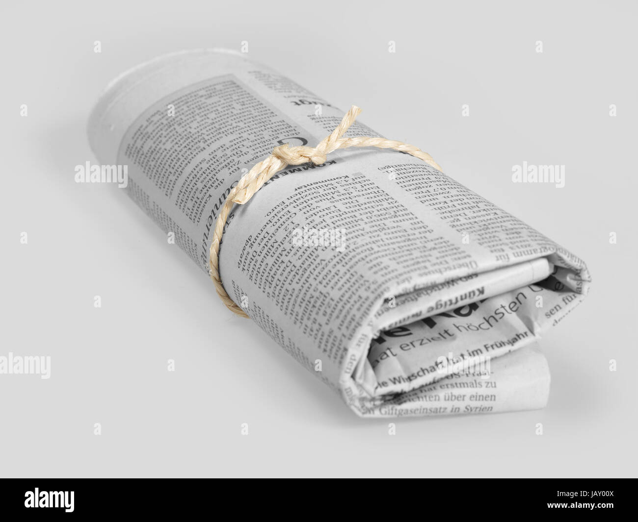 rolled german newspaper in grey back Stock Photo