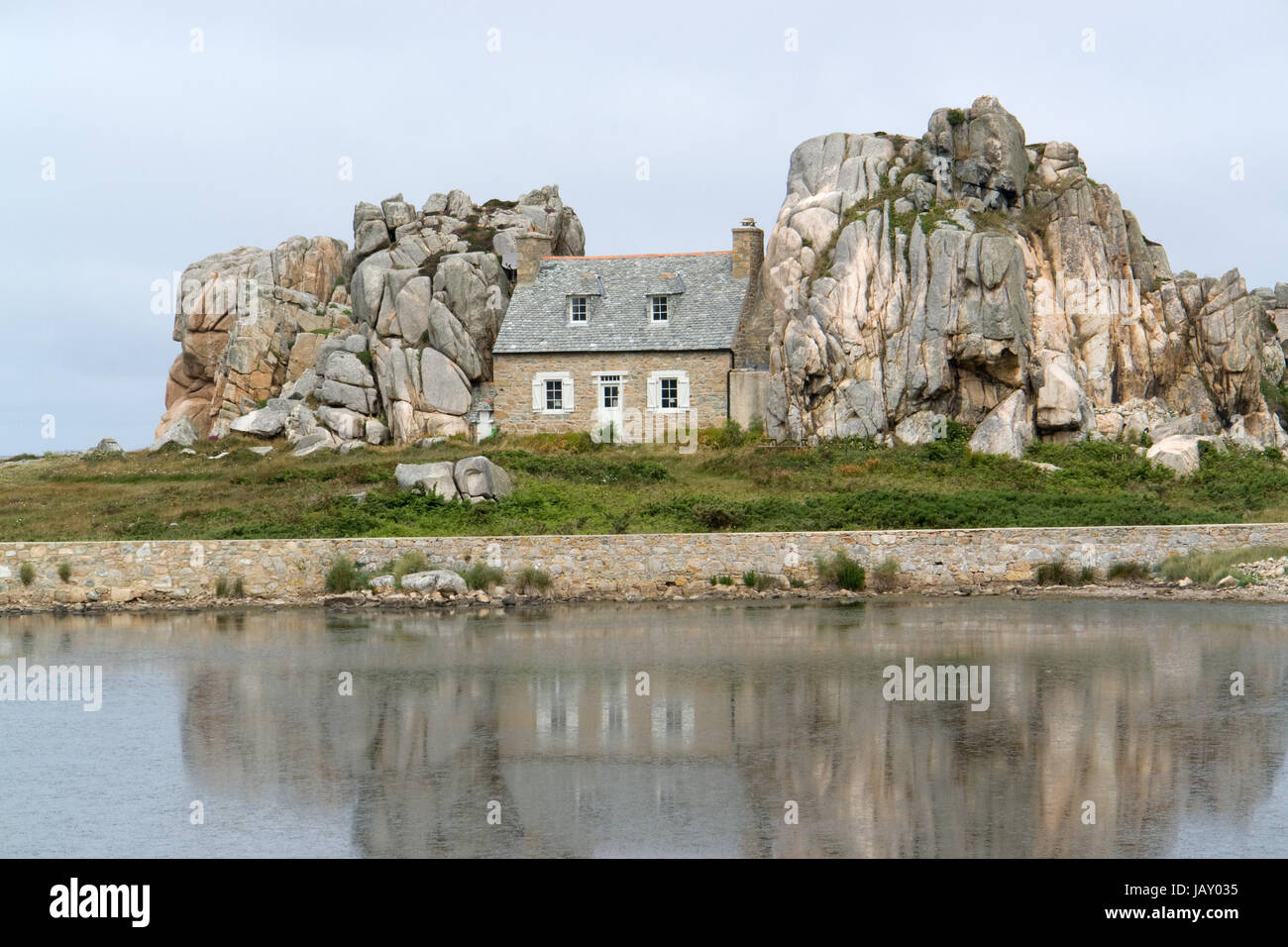 traditional breton house between some rocks at the Pink Granite Coast on Brittany, France Stock