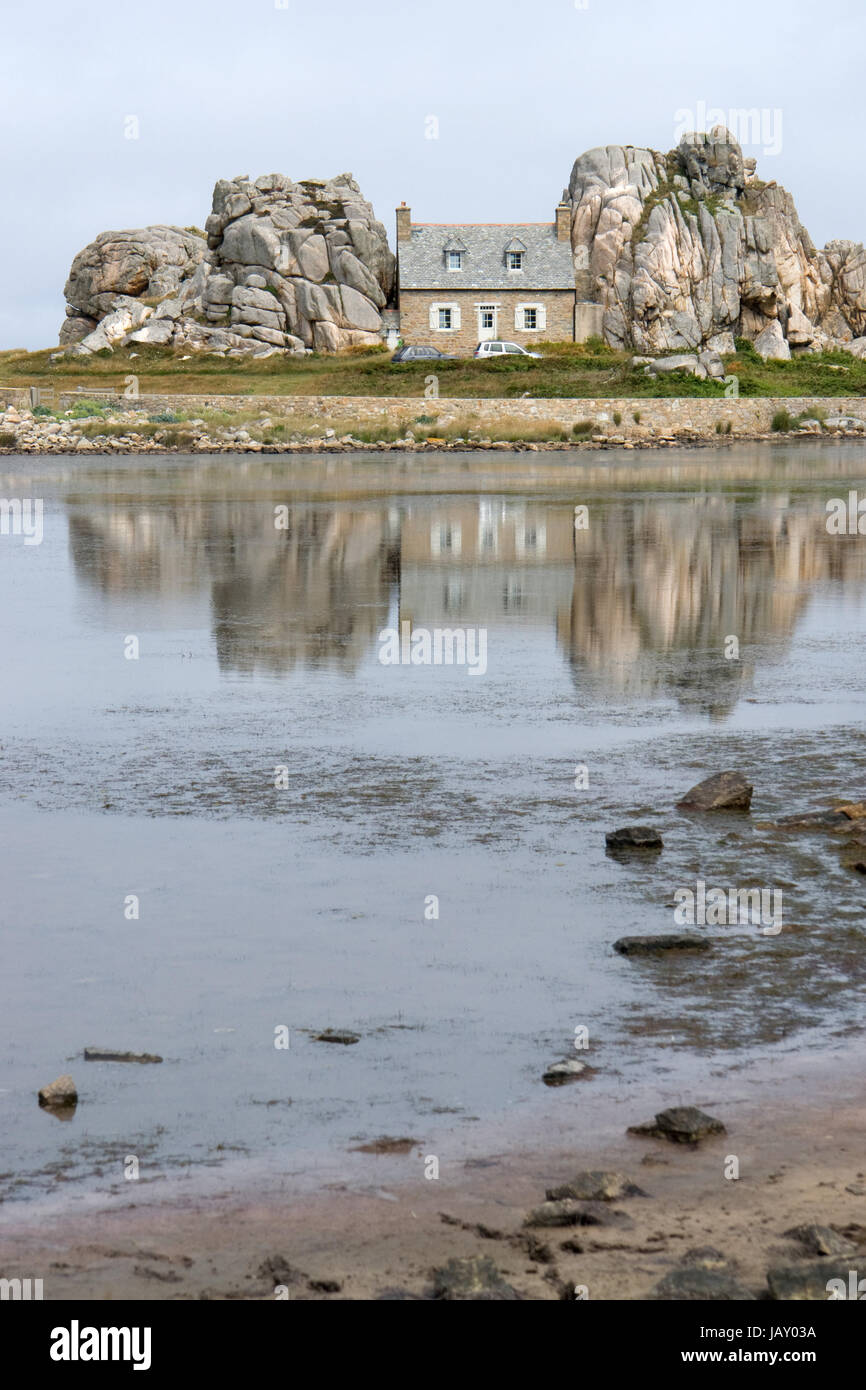 traditional breton house between some rocks at the Pink Granite Coast on Brittany, France Stock