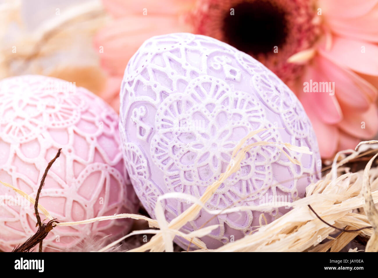 handbemalte dekorierte ostereier in hellen pastell farben mit gerbera im nest stroh dekoration ostern frühling Stock Photo