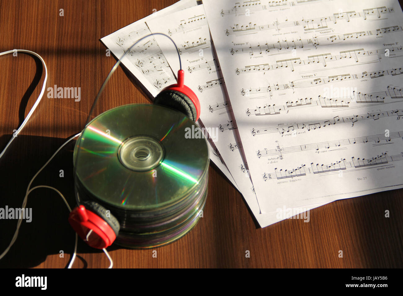 Stack of CDs with headphone and musical notes Stock Photo
