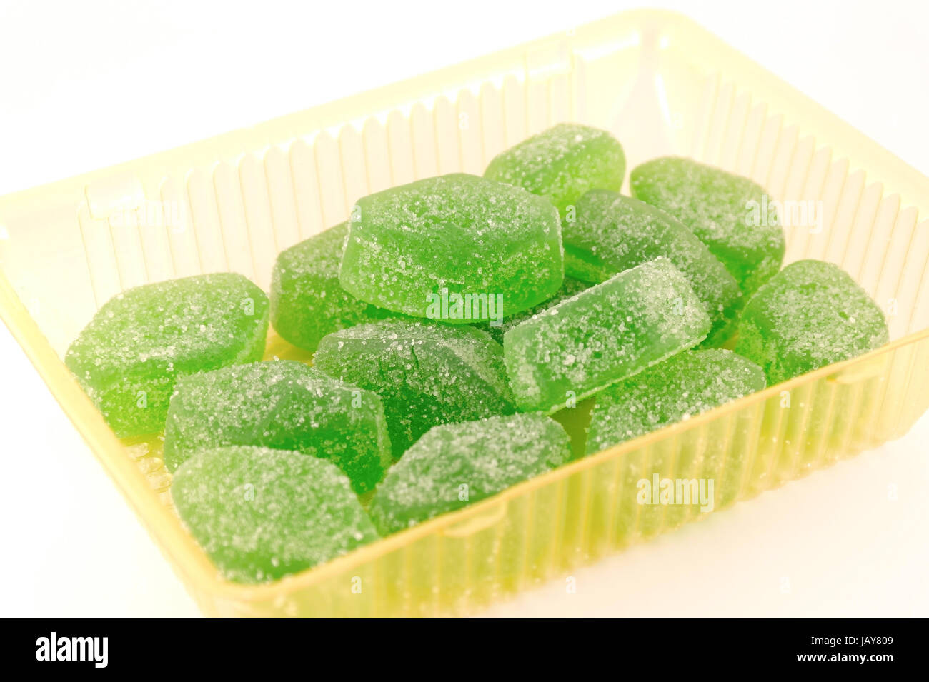 Green fruit jelly in yellow case over white Stock Photo Alamy