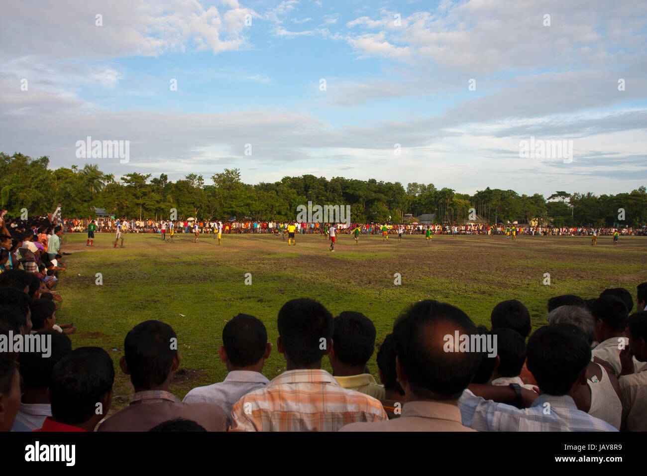 People watch football competition in the village field at Mohonganj. Netrokona, Bangladesh. Stock Photo