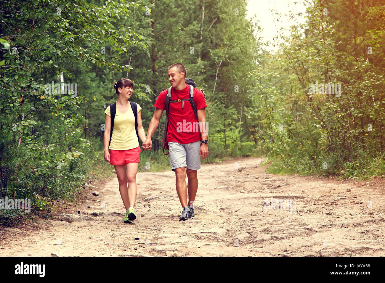 Young couple hikers in forest. sports man and woman with backpacks in ...