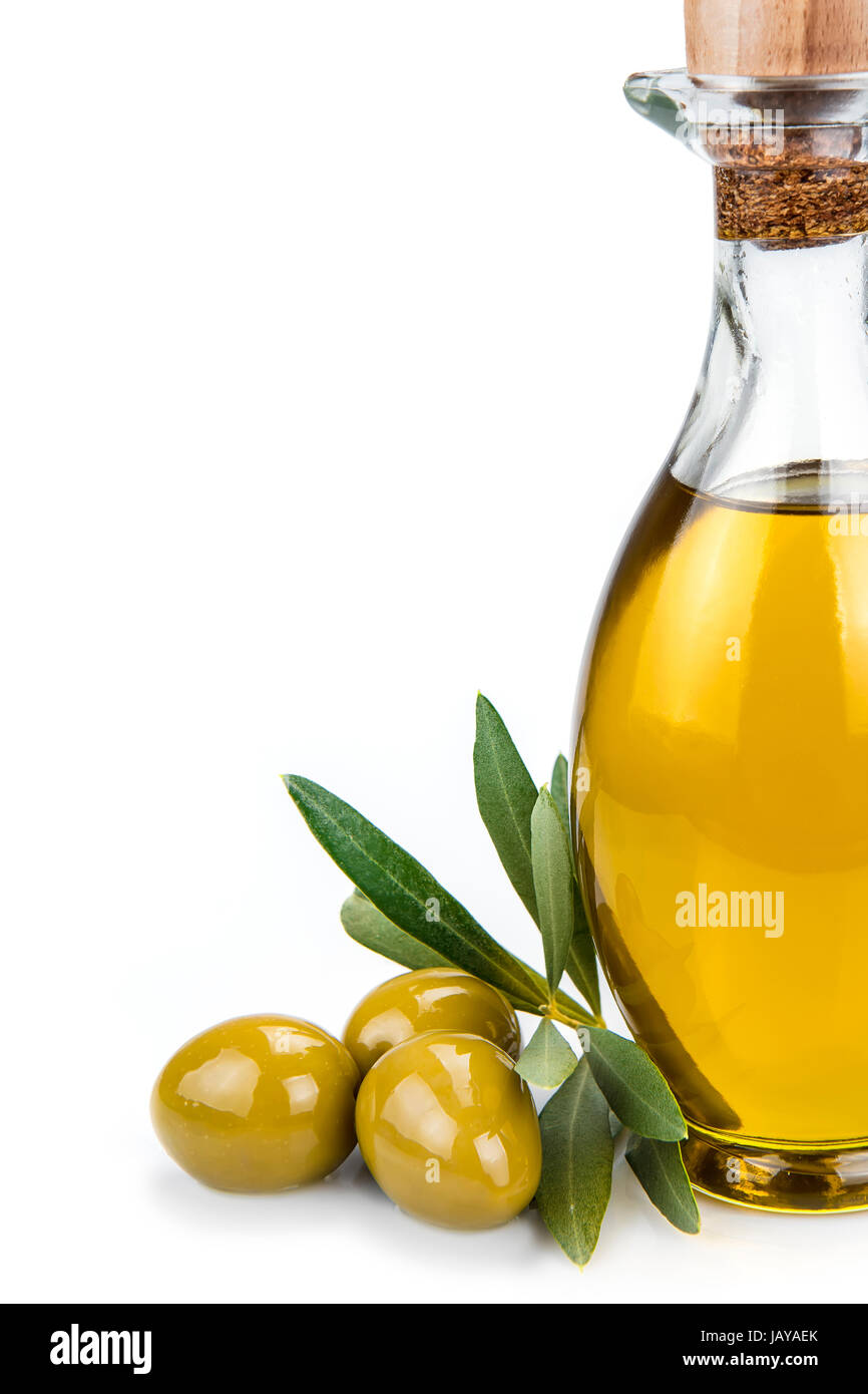Olive oil in a glass bottle and green olives isolated over a white ...