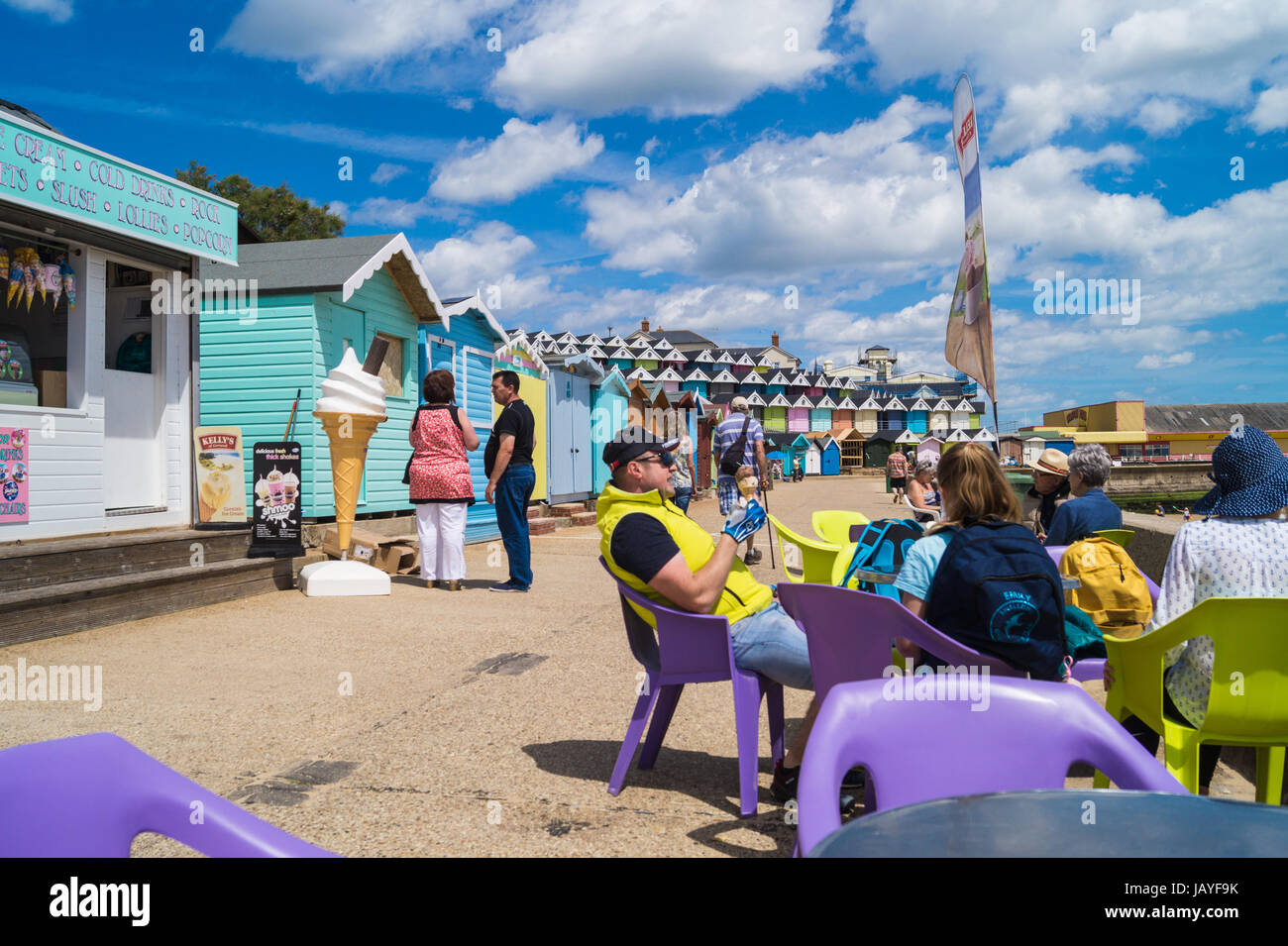 Family enjoying ice cream on the promenade and beach huts, Walton on the Naze, England, UK Stock Photo