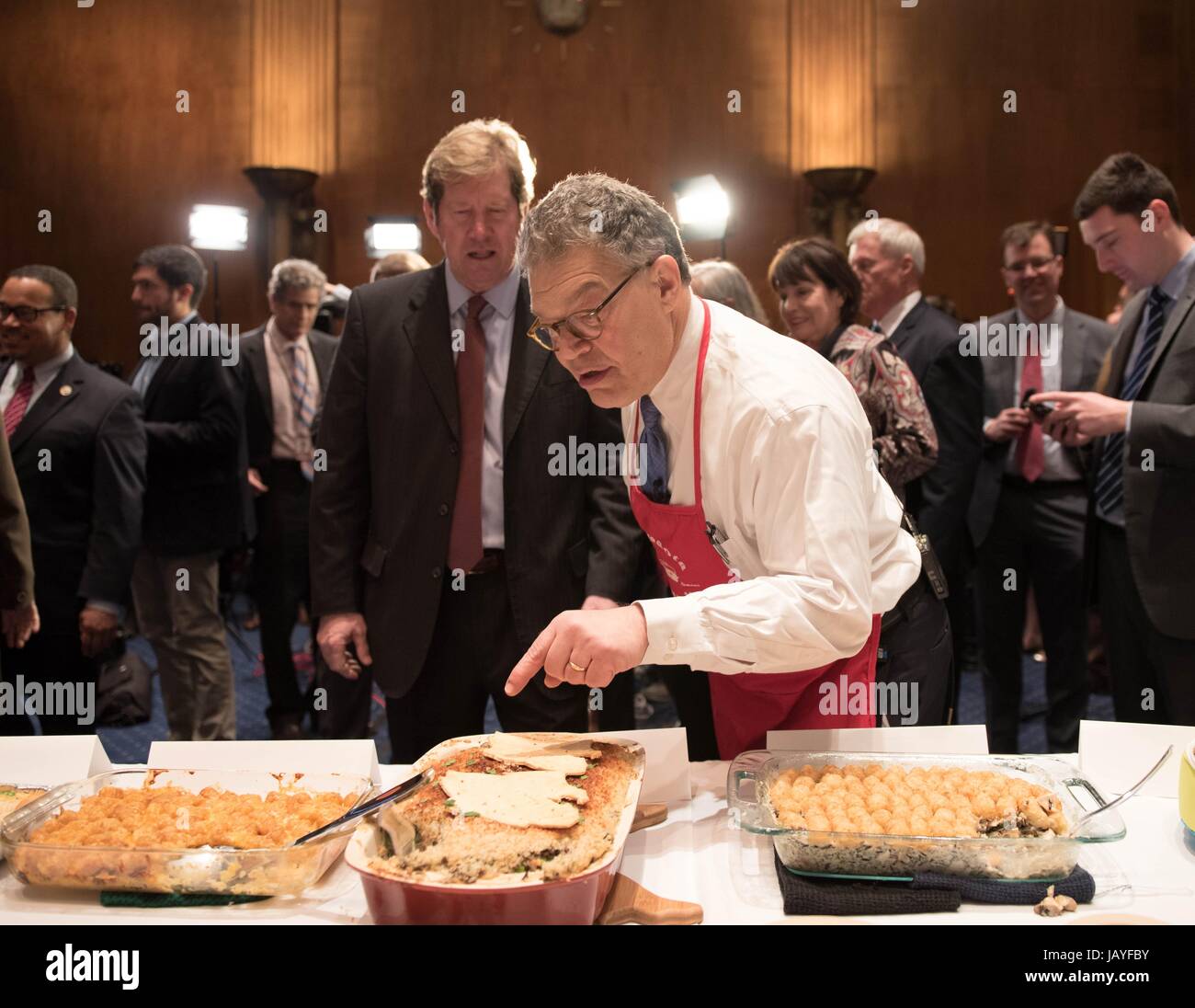 U.S. Senator Al Franken, right, and Rep. Jason Lewis examine food entered in the annual Minnesota Congressional Delegation Hotdish Competition in the Senate Dirksen Building March 8, 2017 in Washington, DC. The cook-off hosted by Sen. Franken brings the Minnesota congressional delegation and their staffs together to to see who can prepare the best midwestern style meal. Stock Photo