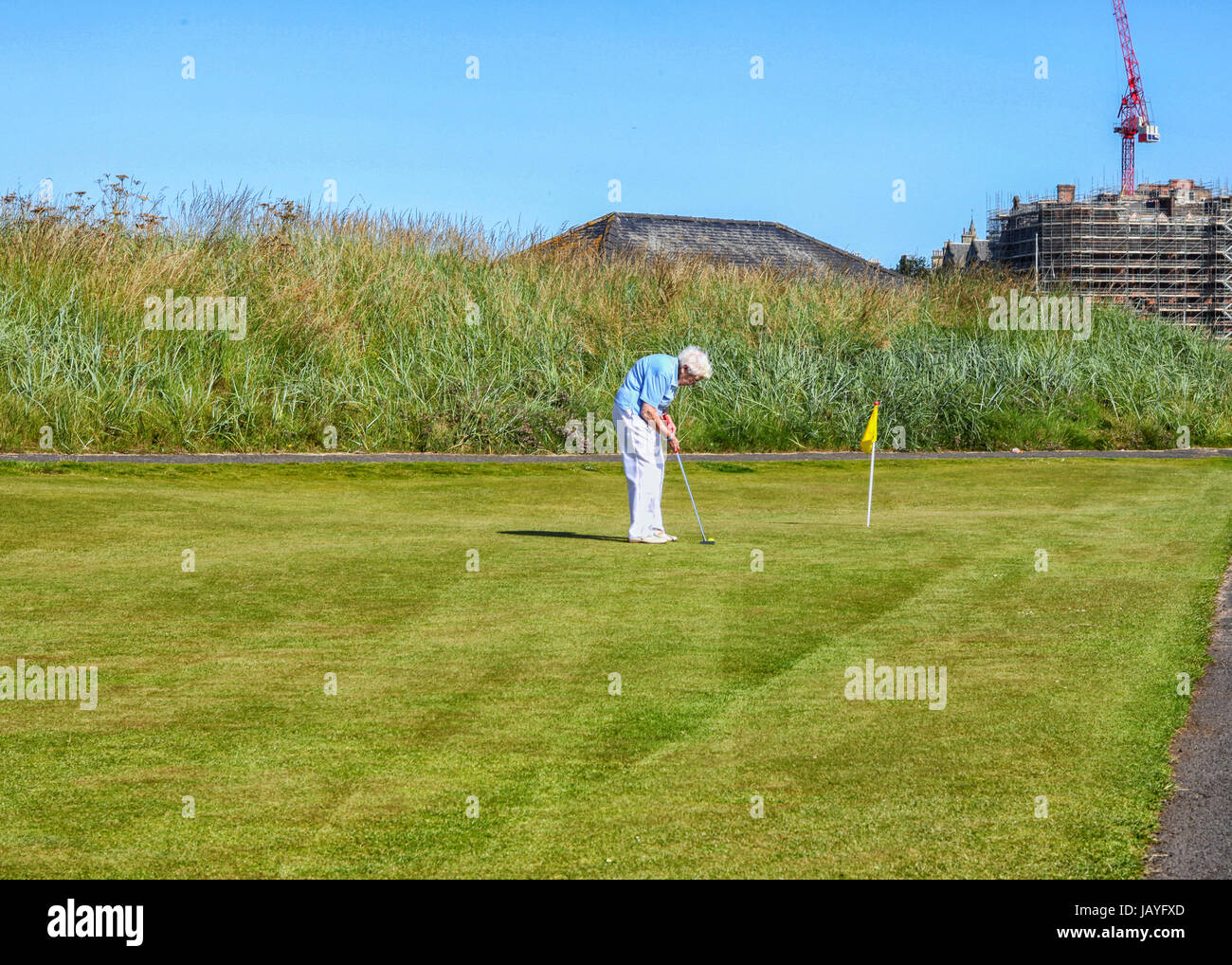 Very old grey haired woman is playing golf at St. Andrews.. Golf is a sport you can maintain up unti Stock Photo