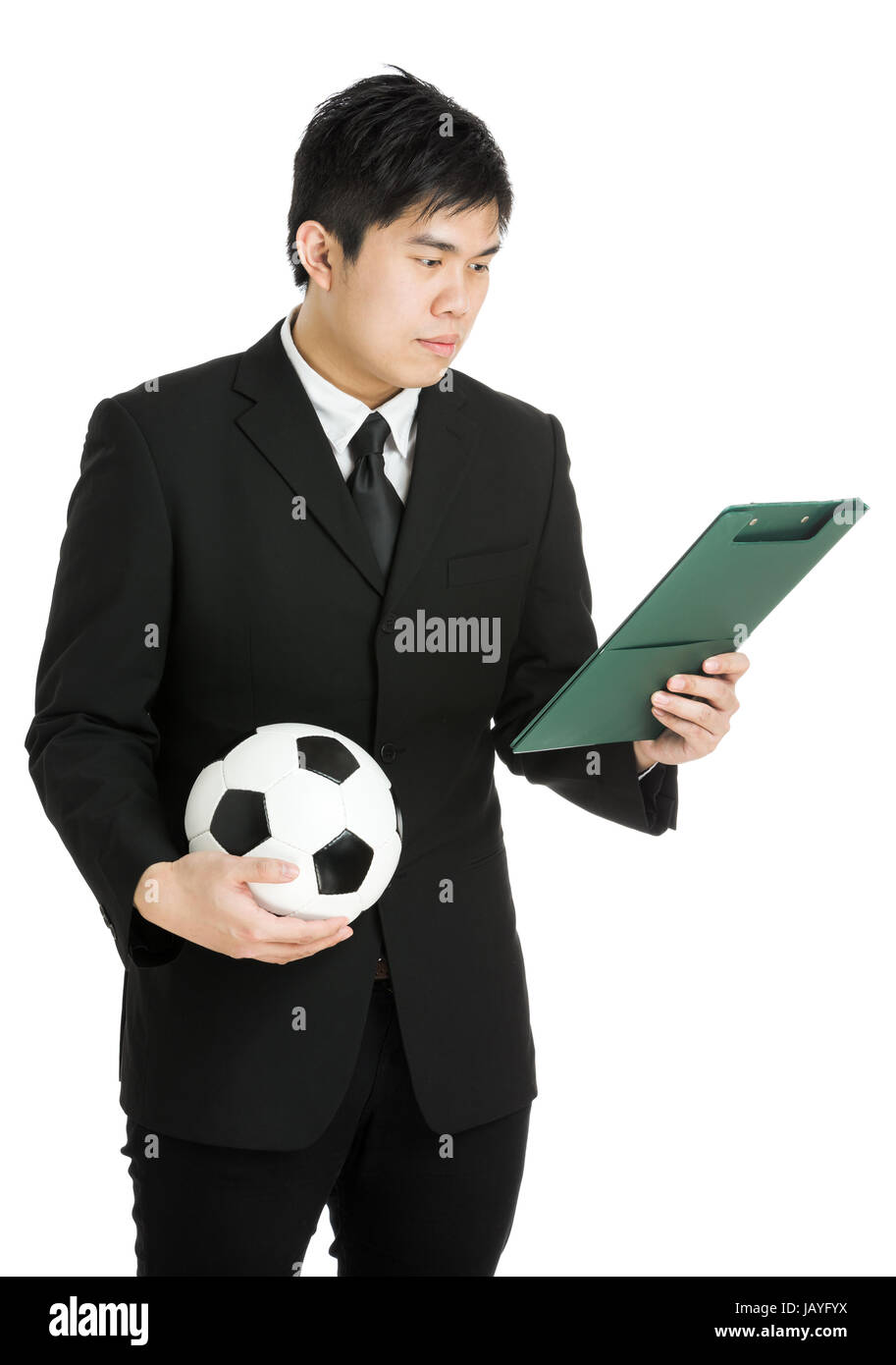 Businessman looking at file pad and holding soccer ball Stock Photo - Alamy