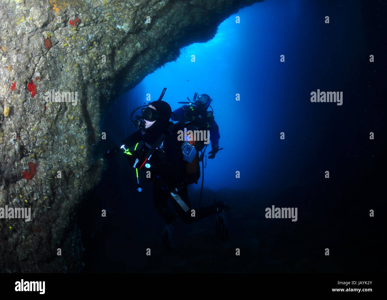 Two scuba divers exploring an underwater cave Stock Photo