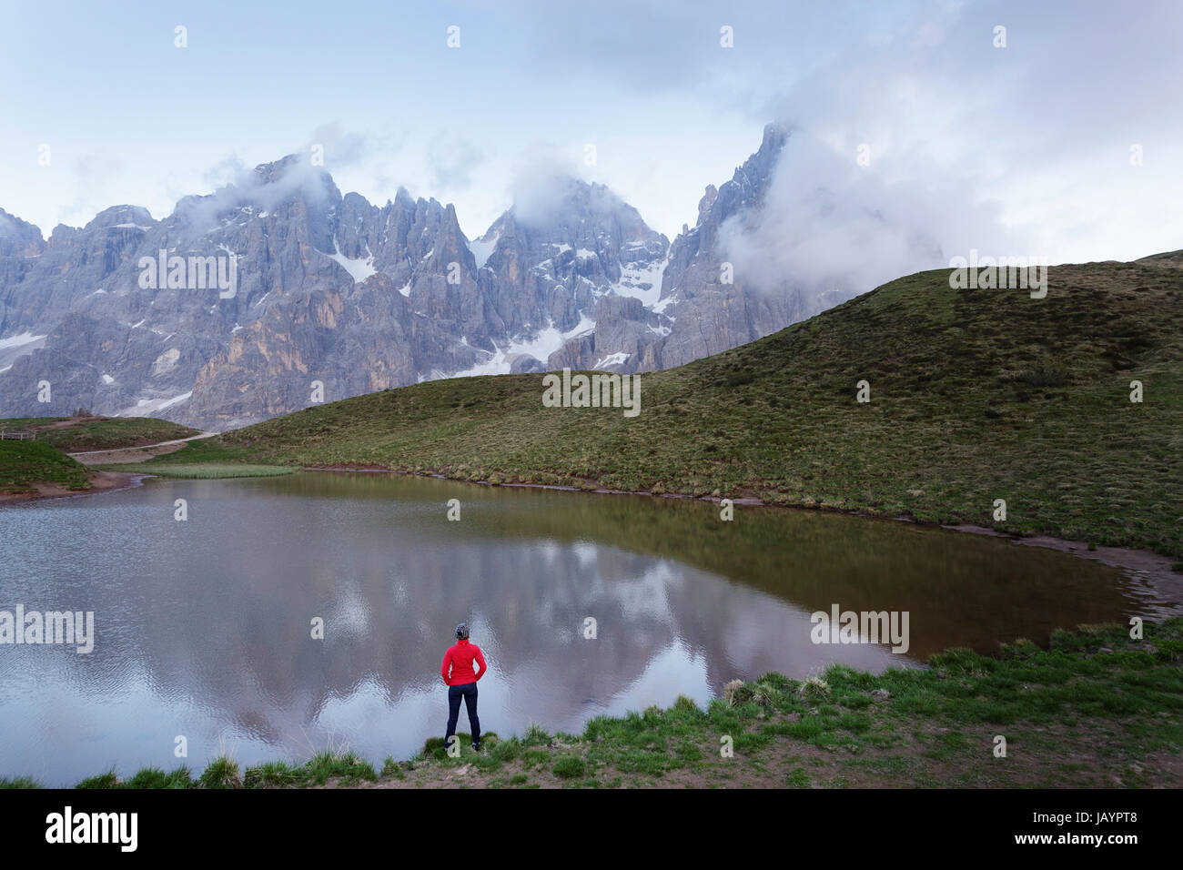 Woman standing by the lake at Baita Segantini, Dolomites, Italy. Stock Photo