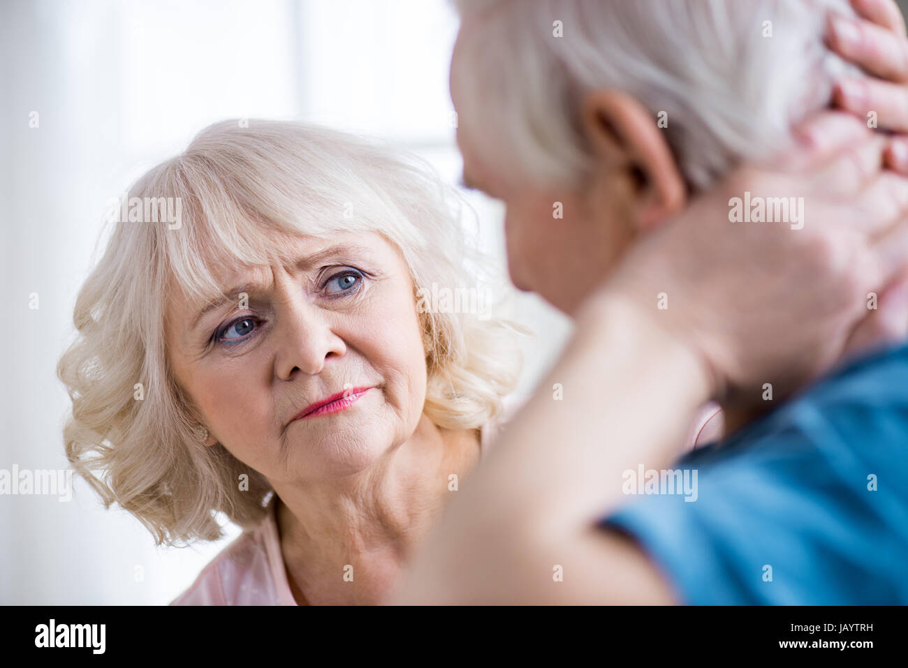 Back view of man with neck pain and concerned woman at home Stock Photo