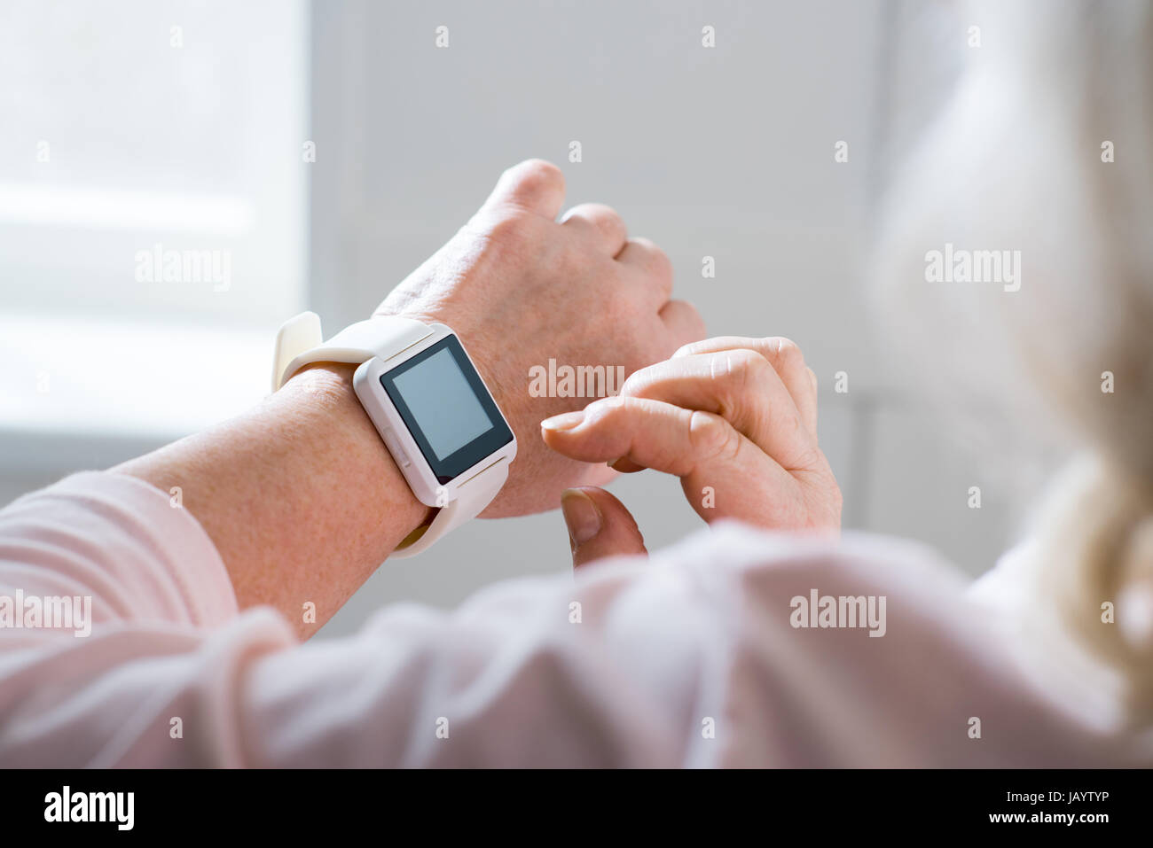 Close-up partial view of senior woman using smartwatch Stock Photo