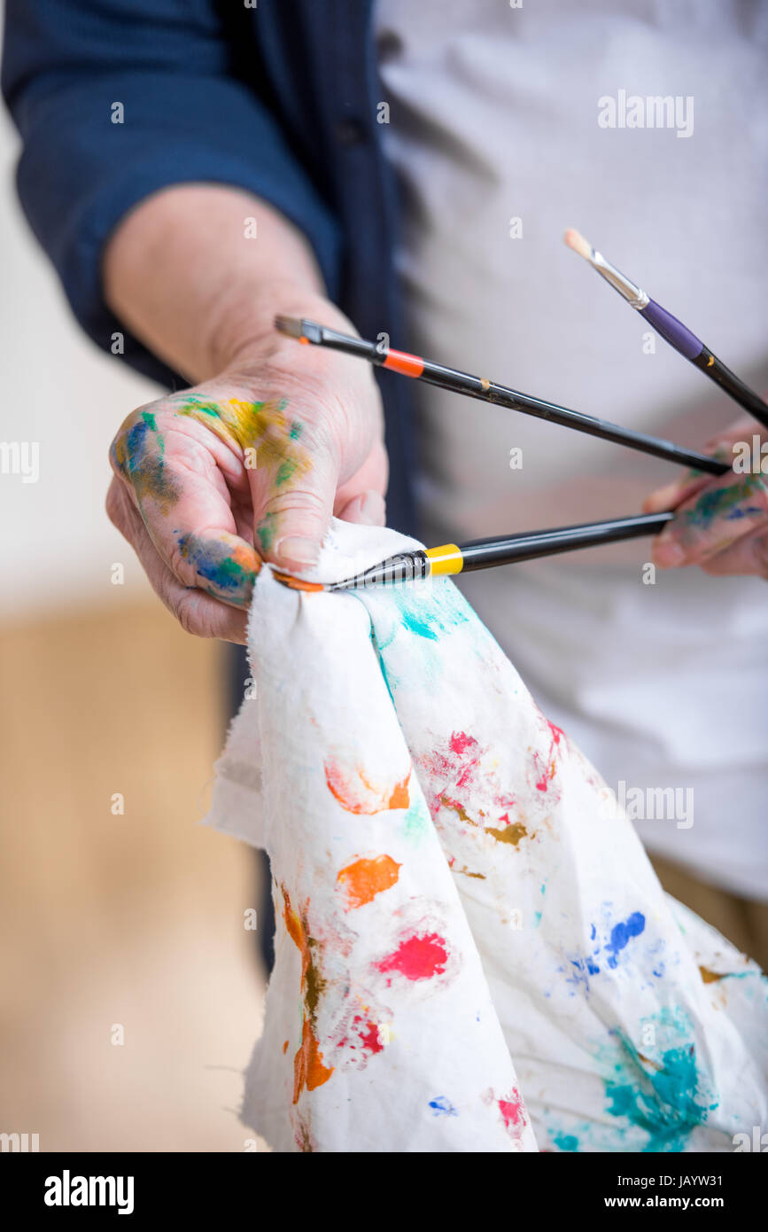 partial view of man cleaning paint brushes in hands Stock Photo