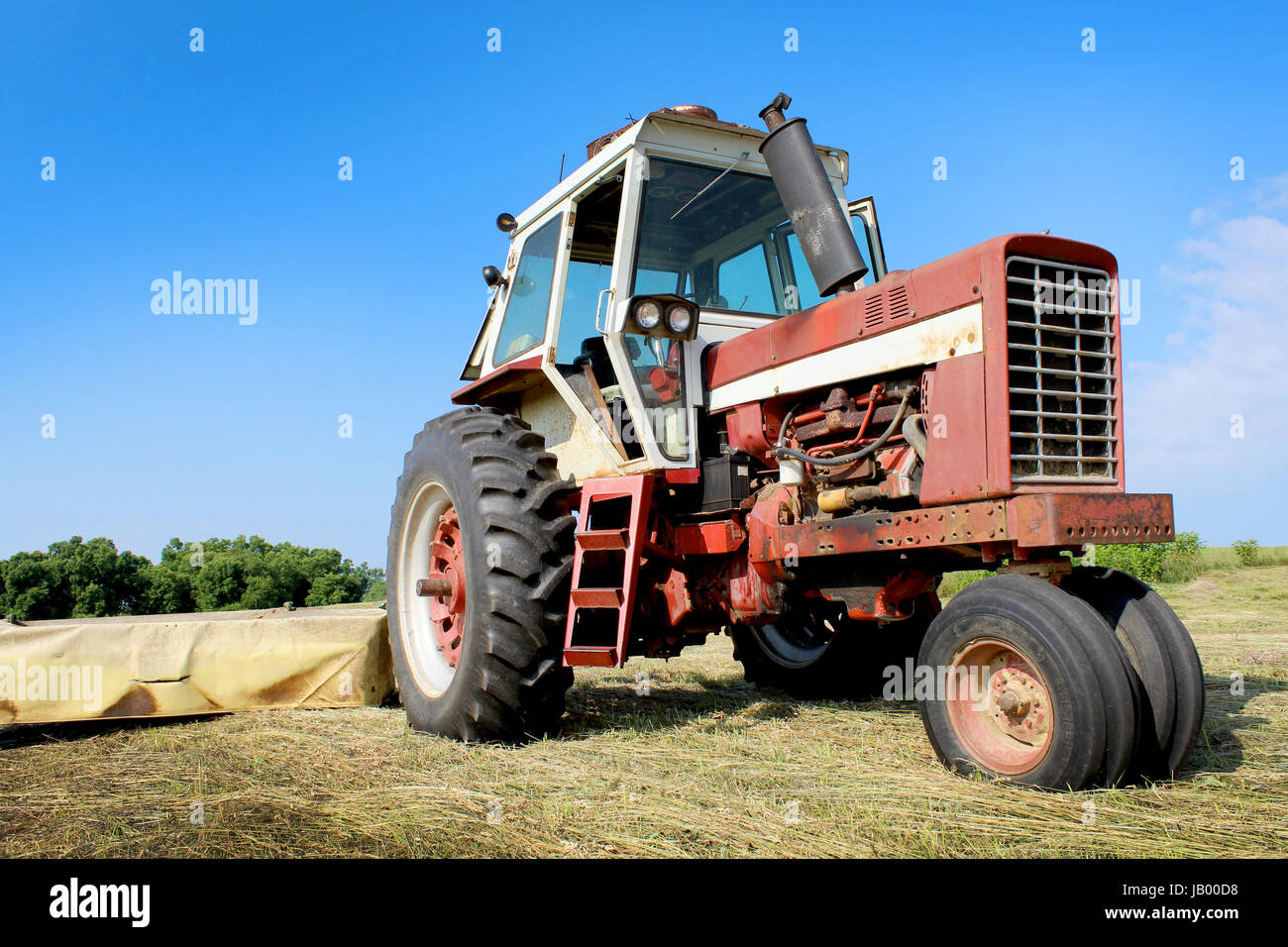 An old tractor in a freshly mowed field Stock Photo - Alamy