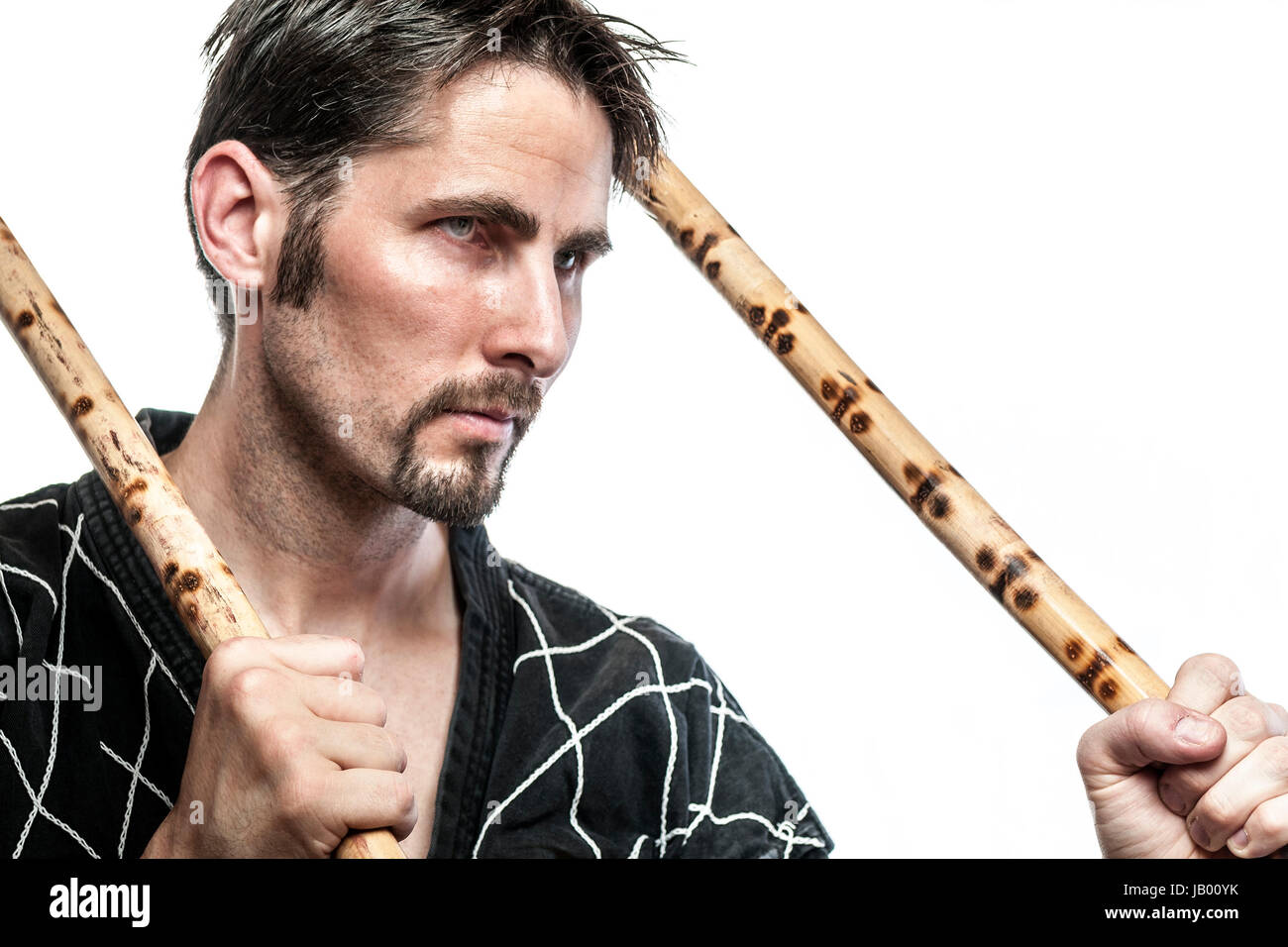 Martial arts master with black combat dress and two short bamboo sticks