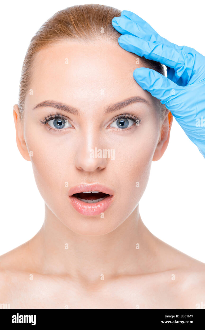 portrait of cosmetologist in latex glove examining face of female patient Stock Photo