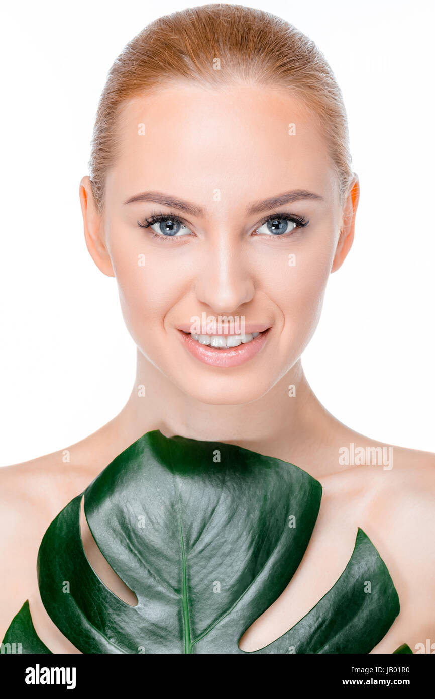 portrait of smiling woman wth leaf looking to camera on white Stock Photo