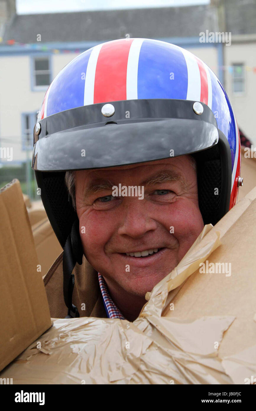 Ayr, Ayrshire, Scotland, UK. Man Union Flag motorcycle crash helmet pokes his head out through a cardbox Stock Photo